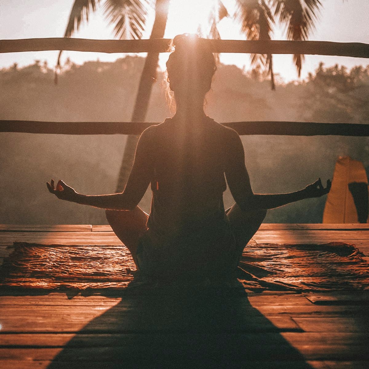 A person sitting calmly in meditation at sunset